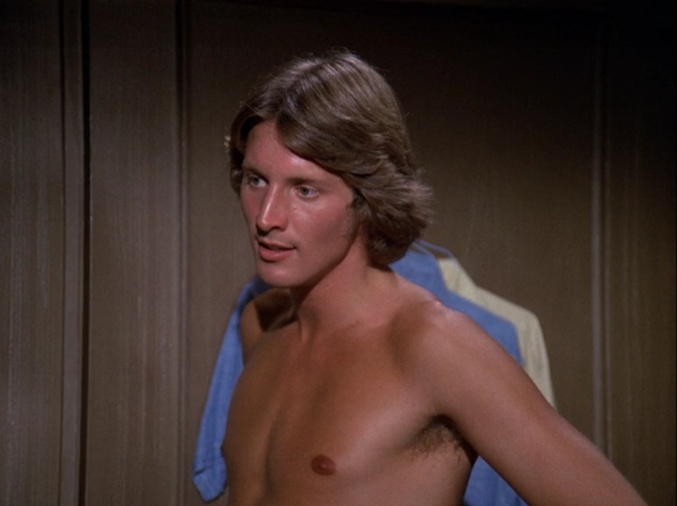 Bruce Boxleitner as Kevin Caulder, a young, tanned white man with longish dark blond hair. He's shirtless.